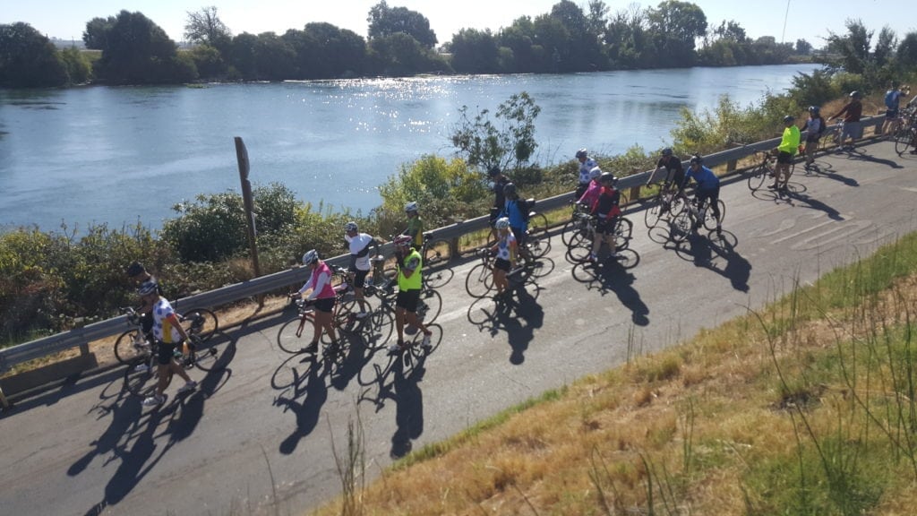 an image of cyclists riding their bikes near the river