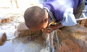 an image of a Kenyan boy drinking water from a water fountain