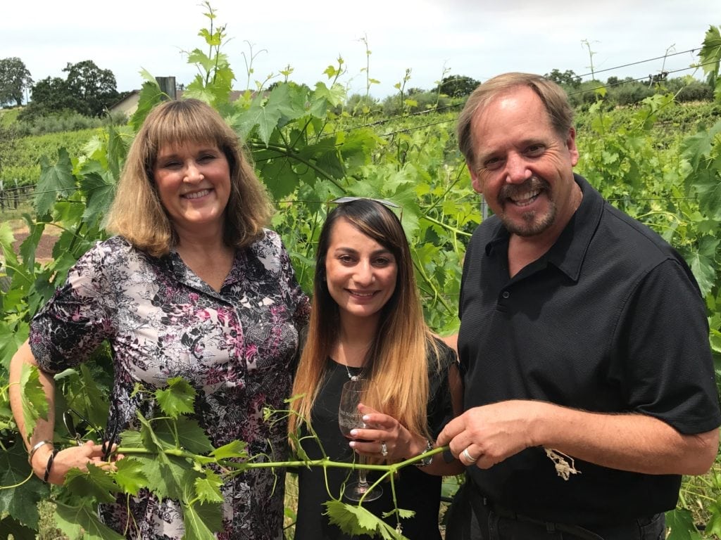 an image of 3 people standing in a large vegetable garden