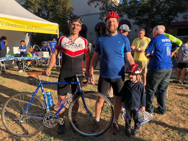 Two adults and a child participate in the Sacramento Century Challenge cycling event.