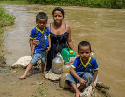 Mother and children at the river gathering water.