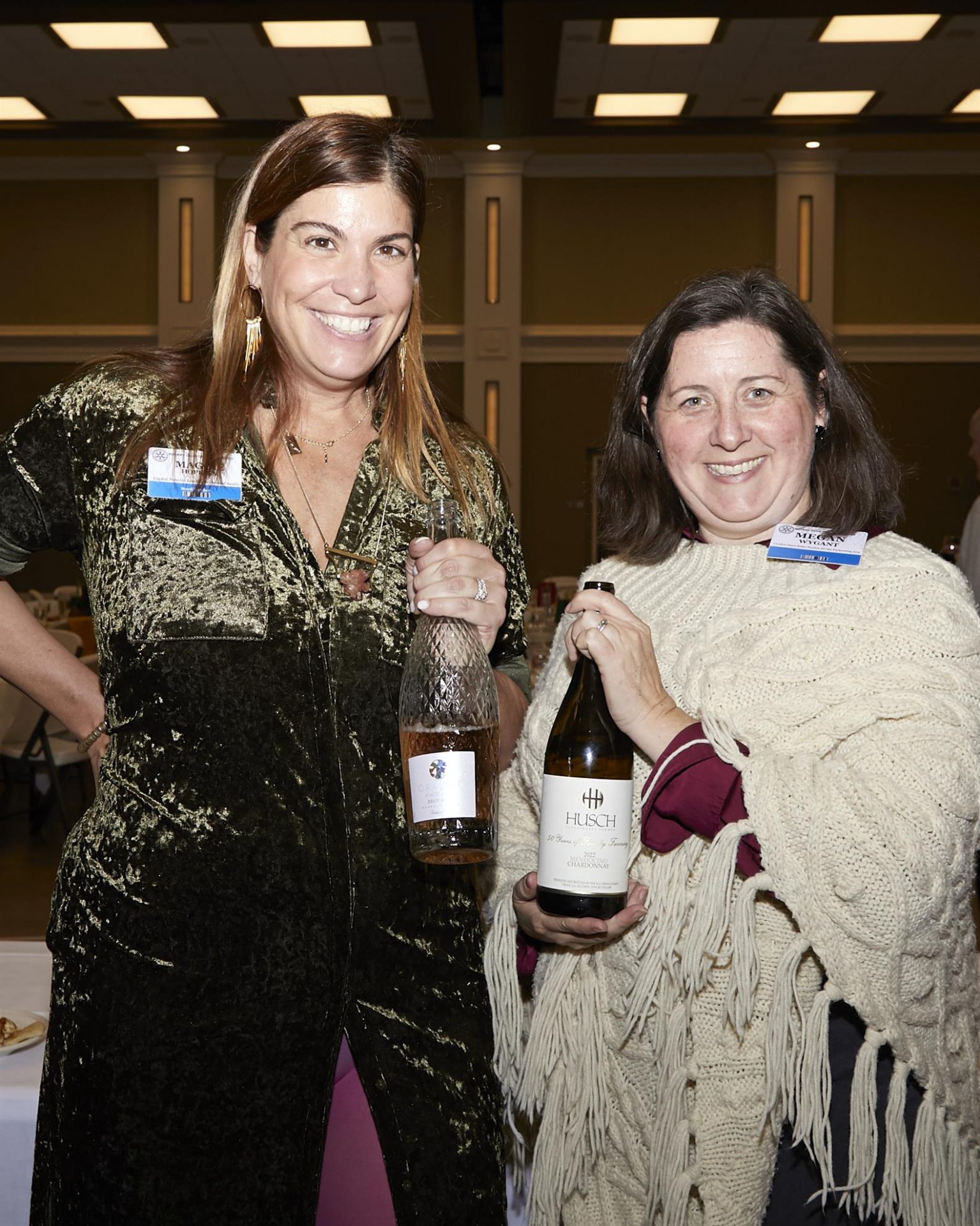 Two women posing with bottles of chardonnay