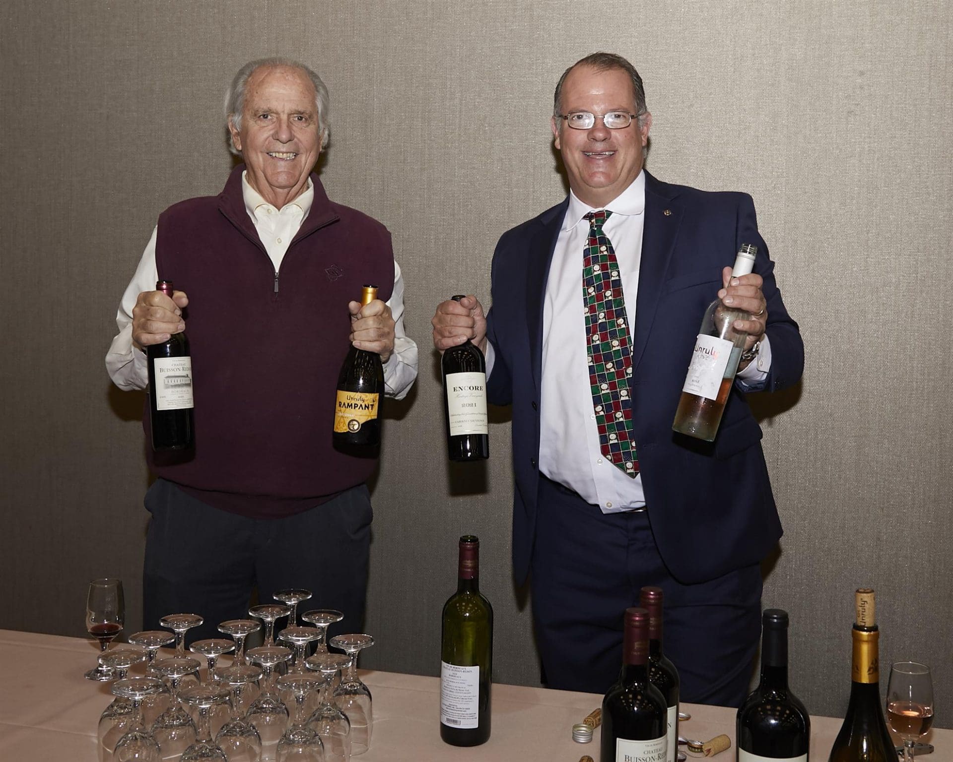 Two men holding wine bottles