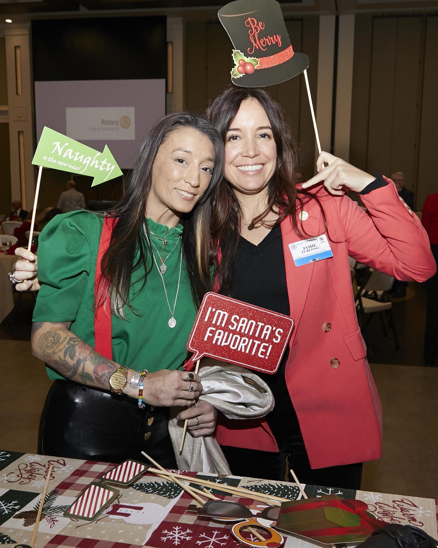 Two woman posing with Christmas photo props