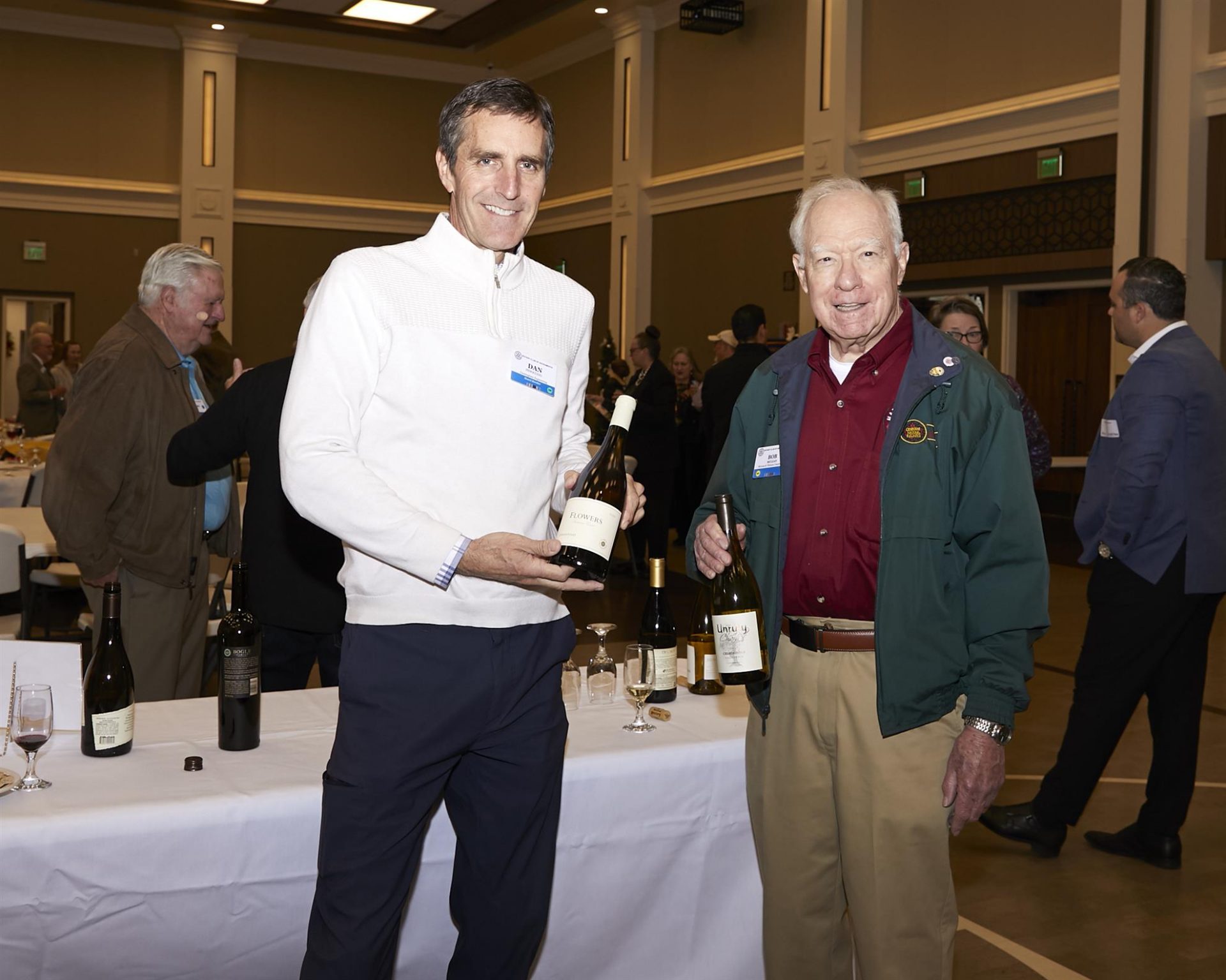 Two men holding bottles of wine