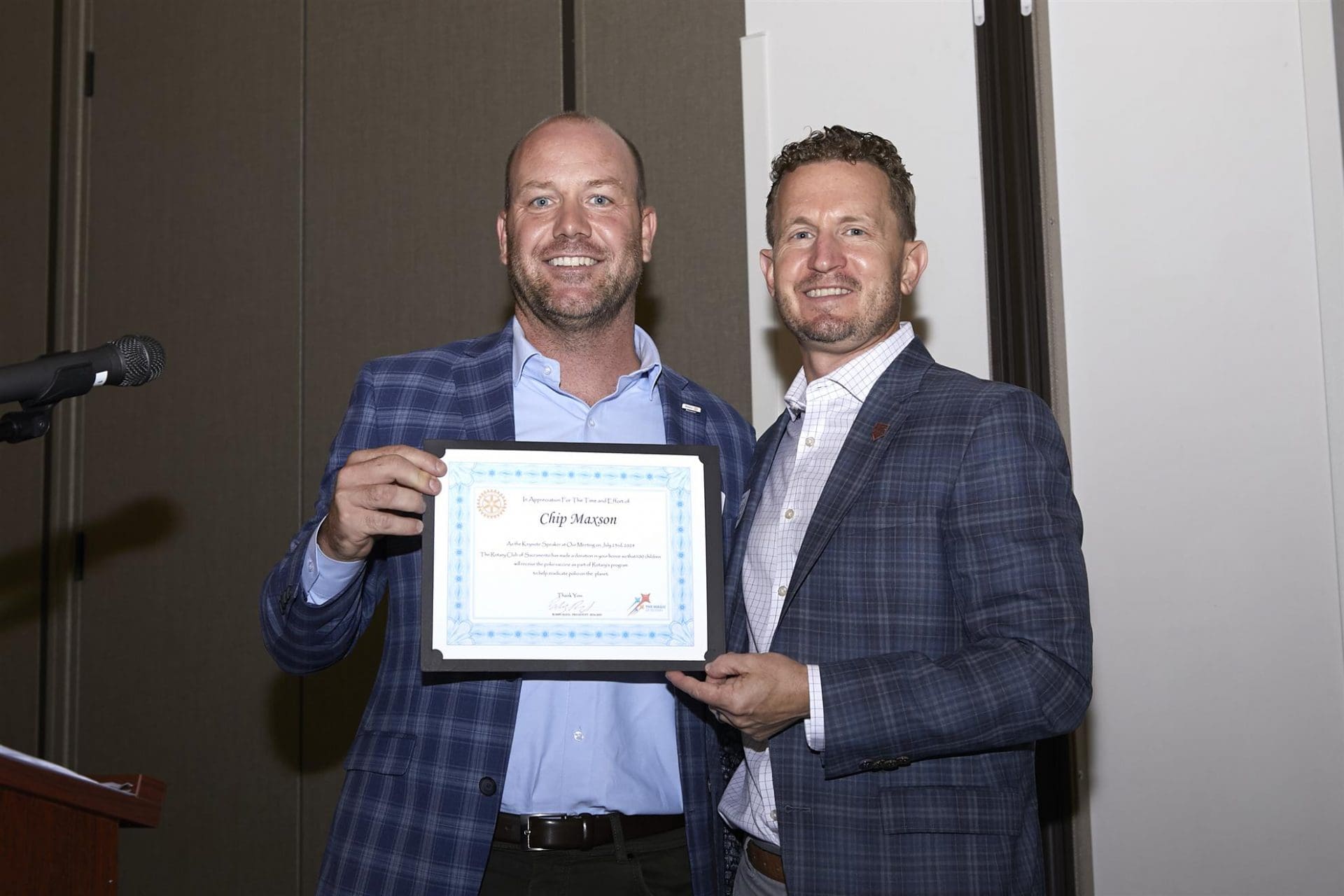 2 people smiling and holding an appreciation paper
