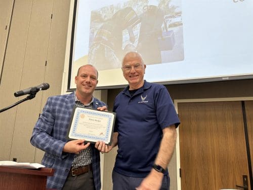 president bobby reed holding up a certificate with a person
