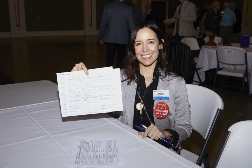 woman holding a paper to the camera