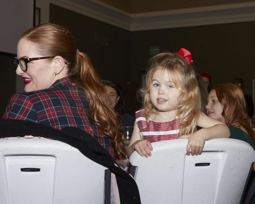adult and child sitting in chair and looking back at camera