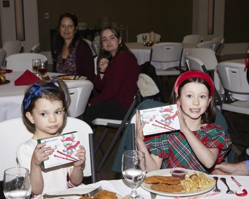 two children holding up a gift