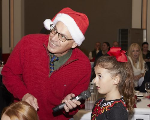 adult holding microphone for child to speak into