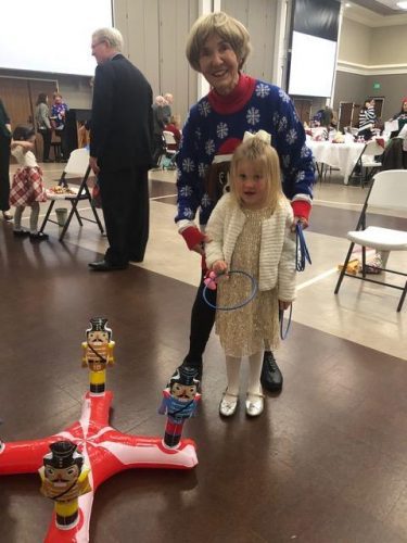 adult helping kid play with a toy