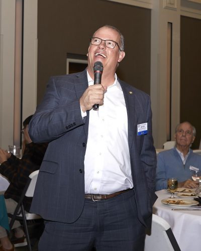 person looking up smiling while holding microphone close to their mouth