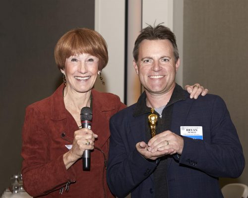 two people looking at camera and holding micorphones