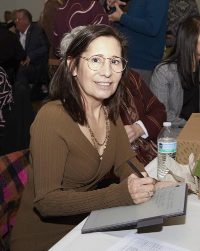 person at desk writing something on paper