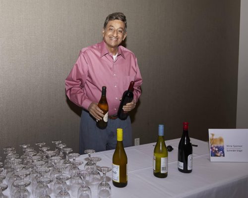 person standing behind table of wine glasses