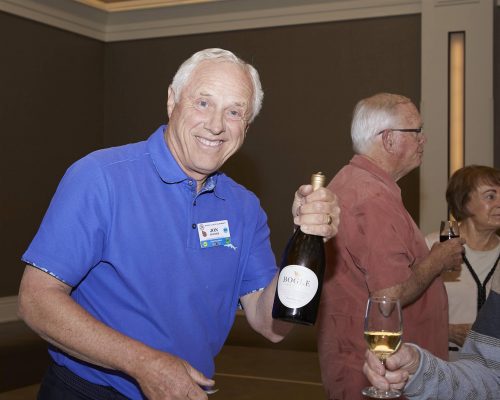 person holding a bottle and smiling at the camera