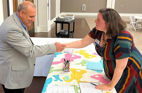two people shaking hands across a table