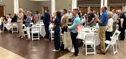 group photo of people standing from their seats
