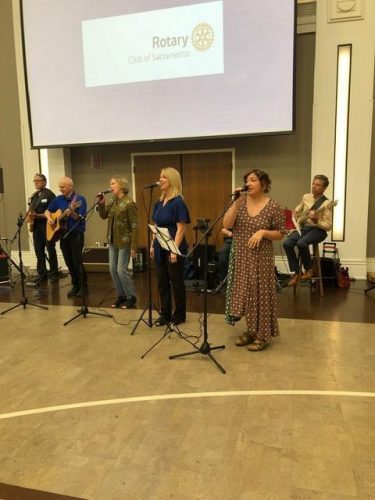 group of people playing instruments into the microphone