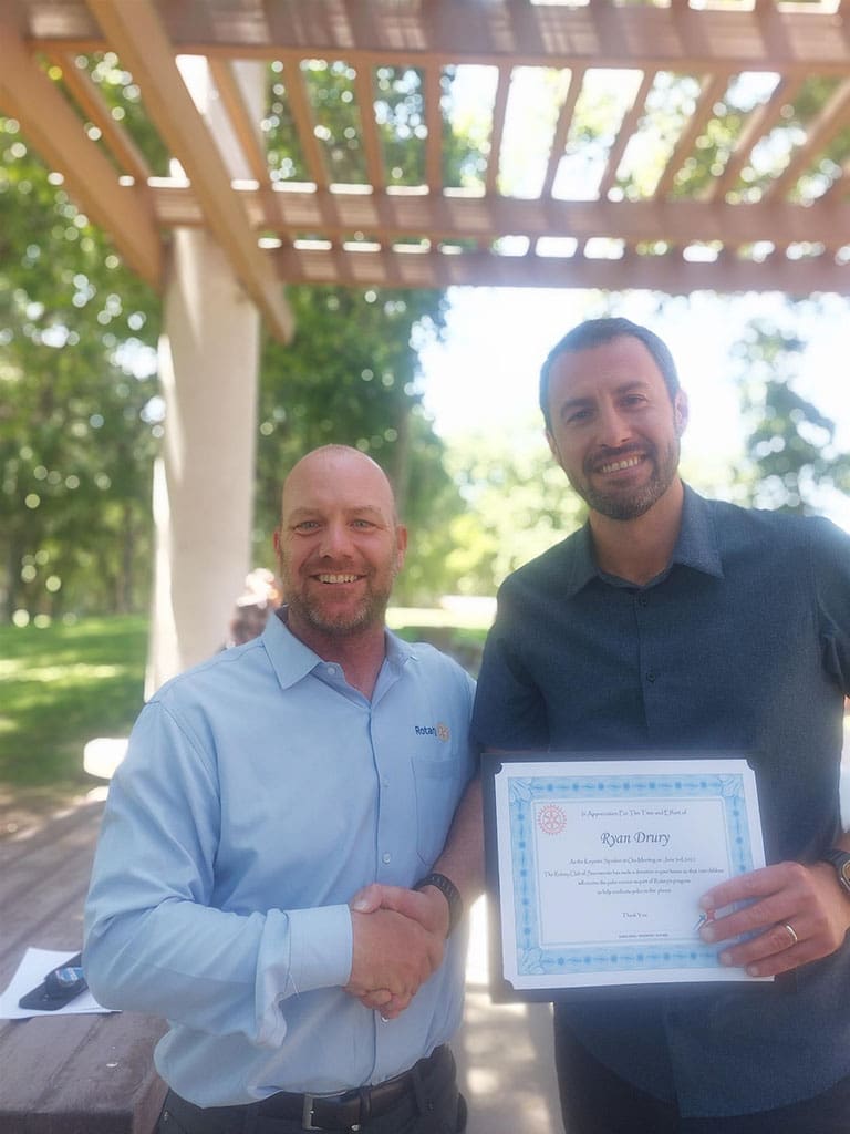 Ryan shaking hand with Bobby while holding certificate