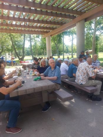 People sitting on the bench turning to direction of the speaking person