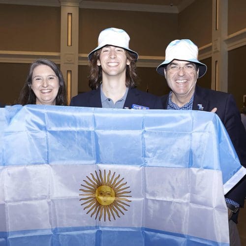 3 people holding up the argentina flag