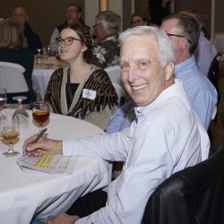A photo of people at an event sitting at round tables