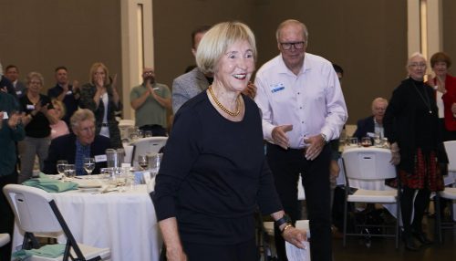 A woman in a navy blue dress and short blonde hair