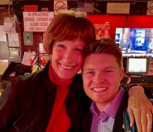A woman and young man smile at the camera