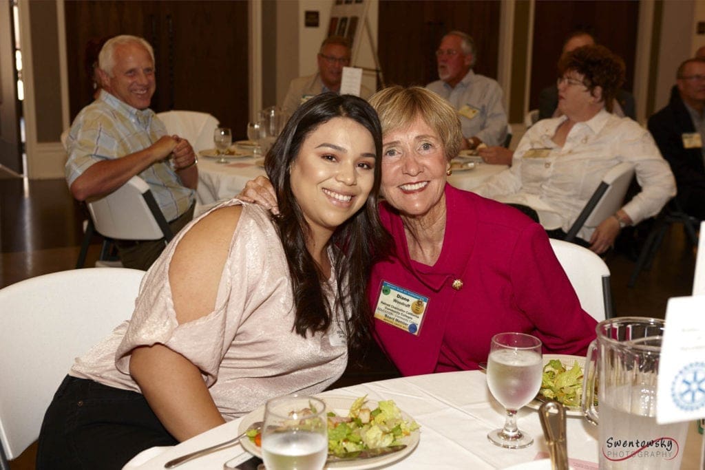 two women sitting at a banquet table together