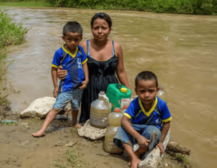 Mother and children at the river gathering water.