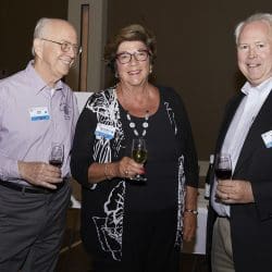 3 people smiling and holding bottles