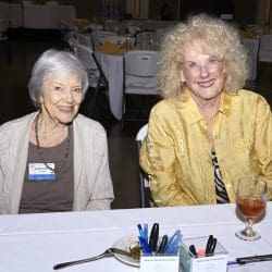 Two people by table smiling