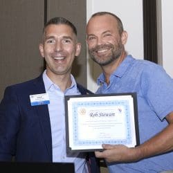 two people smiling and holding a certificate