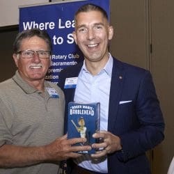 two people smiling and holding a book