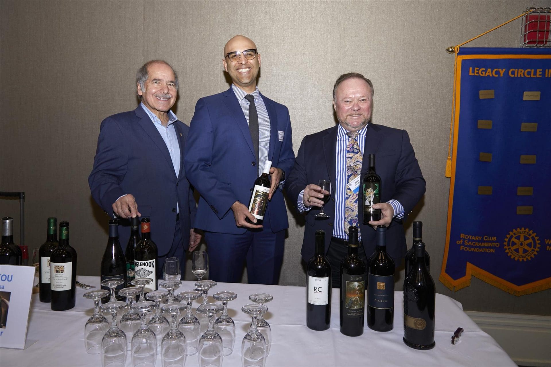 3 people smiling and holding bottles