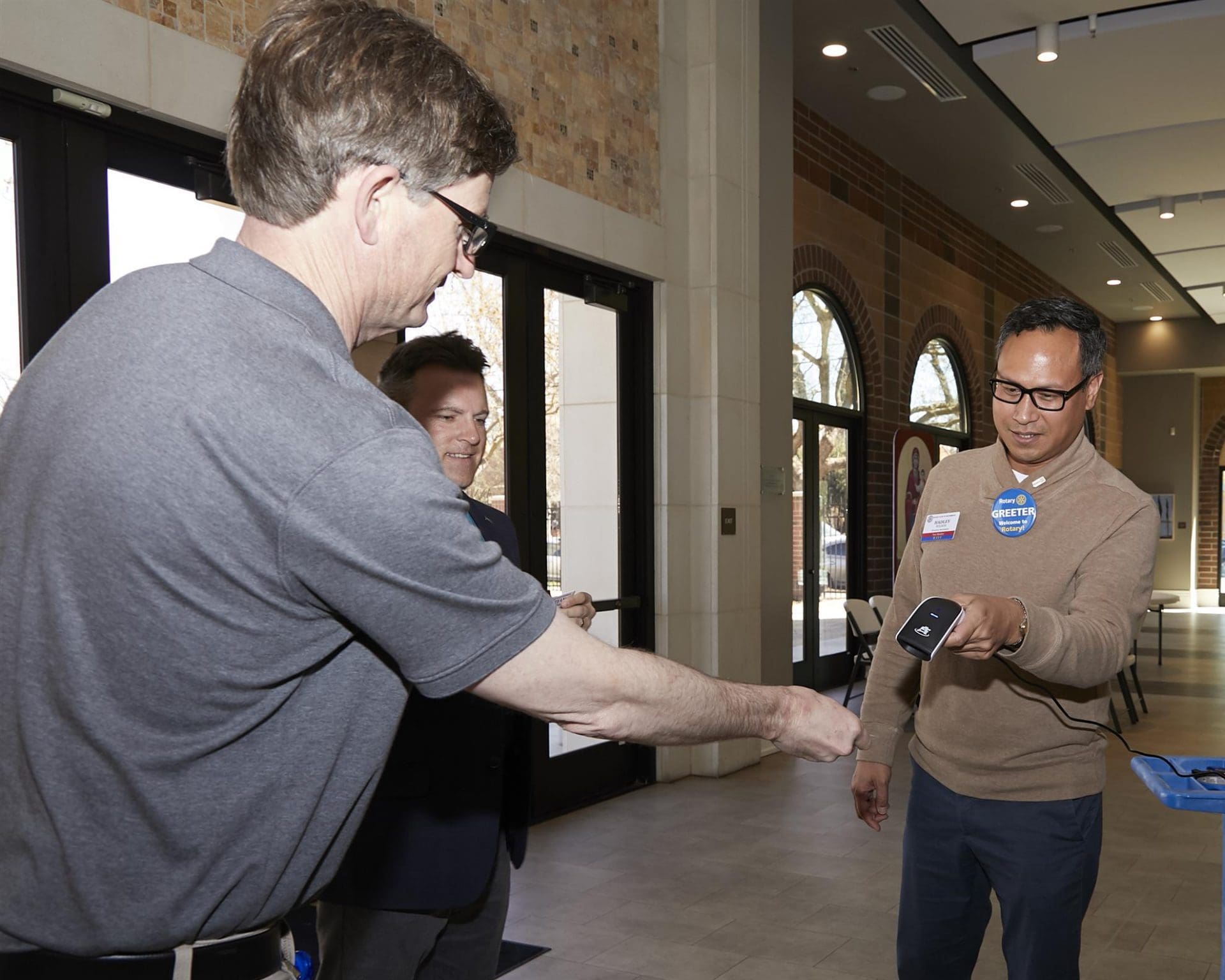 person extending their arm to someone so they can scan it with a scanner