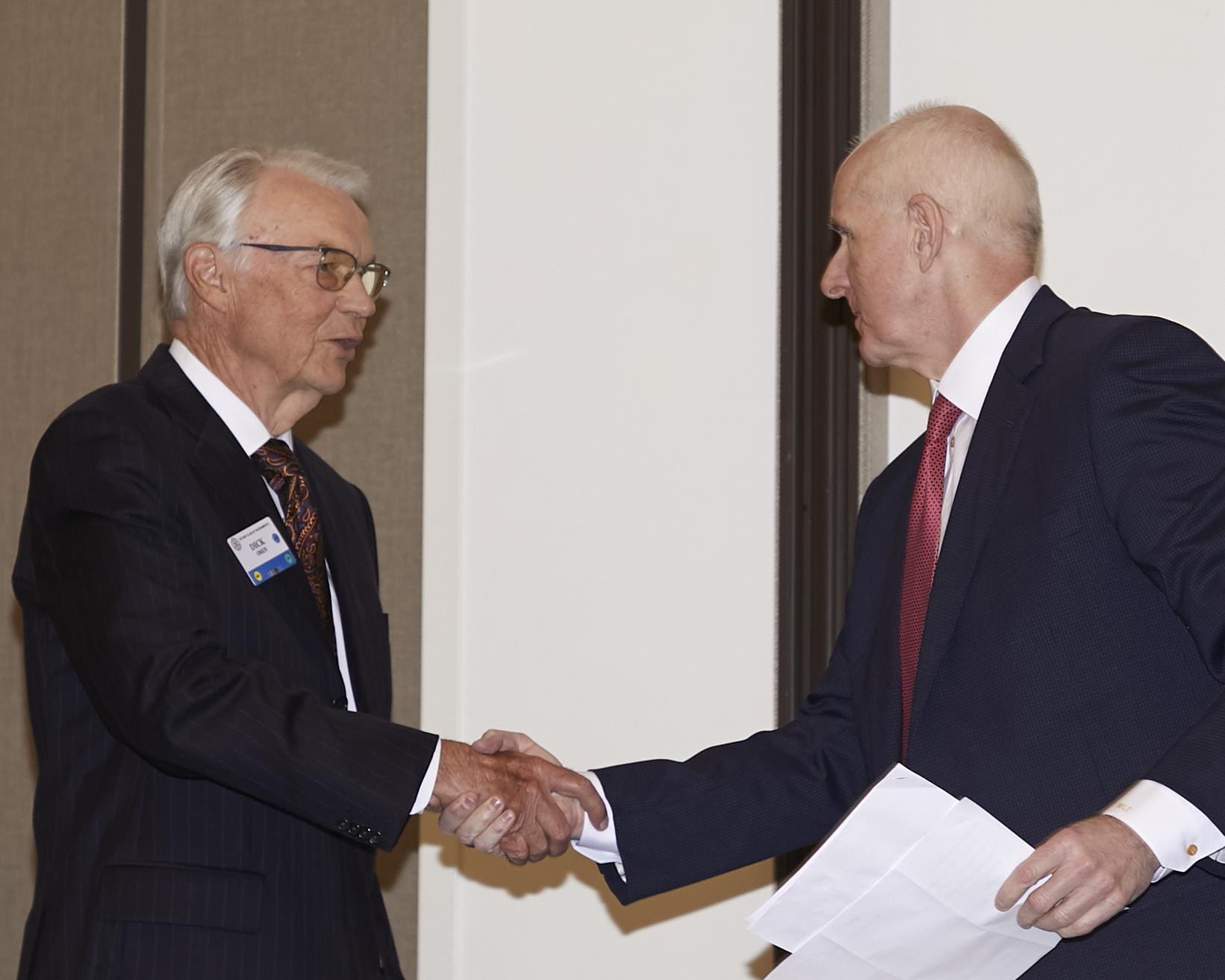 2 people looking at each other and shaking hands