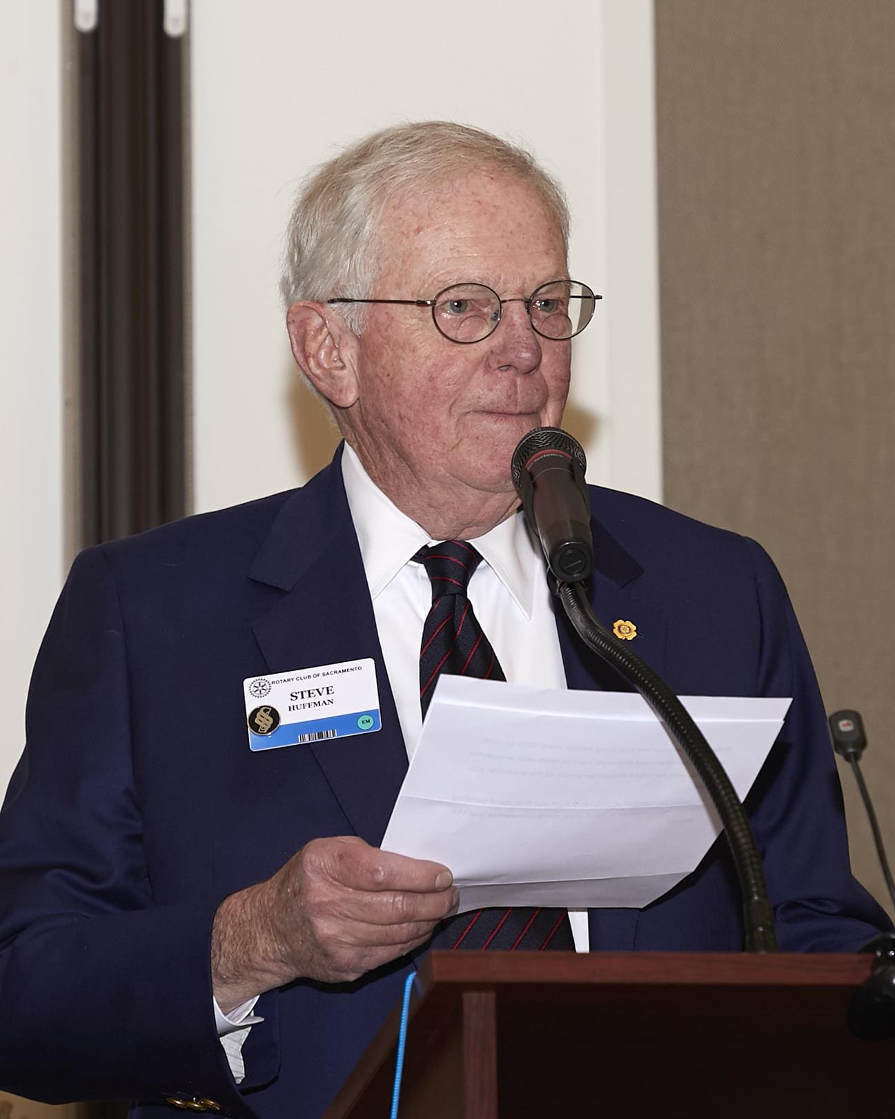 person holding a paper and speaking into a microphone