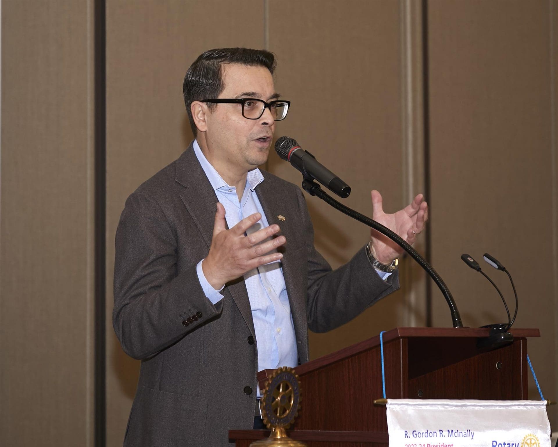 person speaking into a microphone and waving their hands
