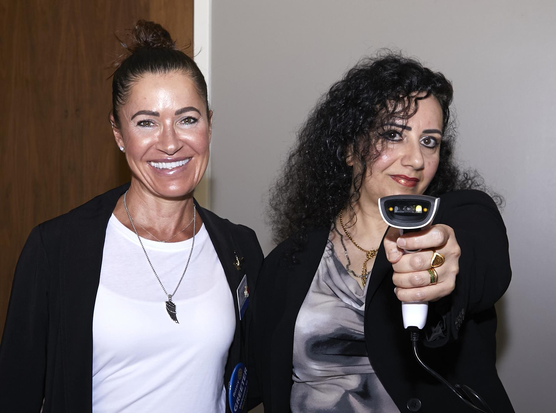 2 people smiling with 1 pointing a scanner to the camera