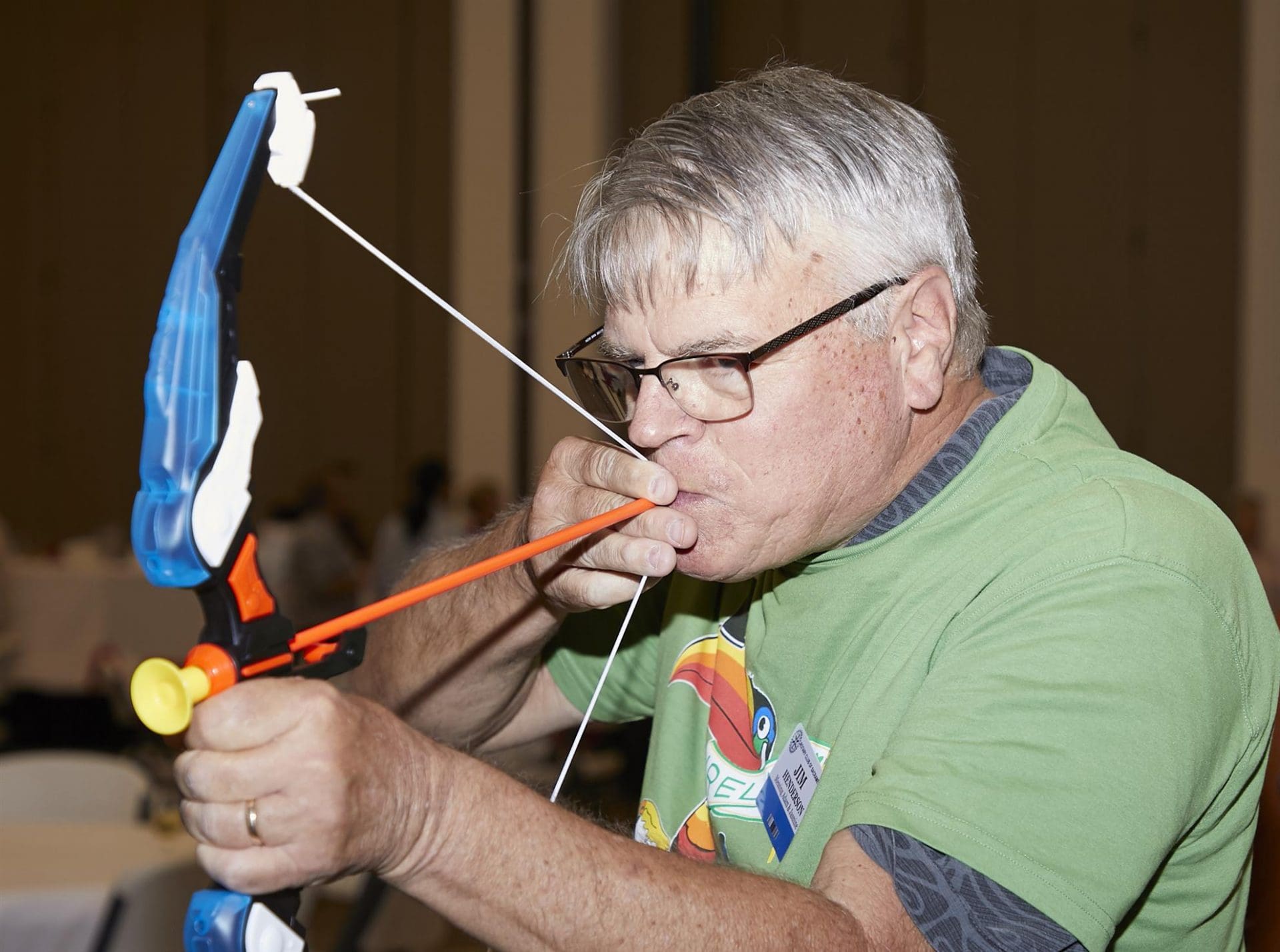person aiming a toy bow and arrow at something off camera
