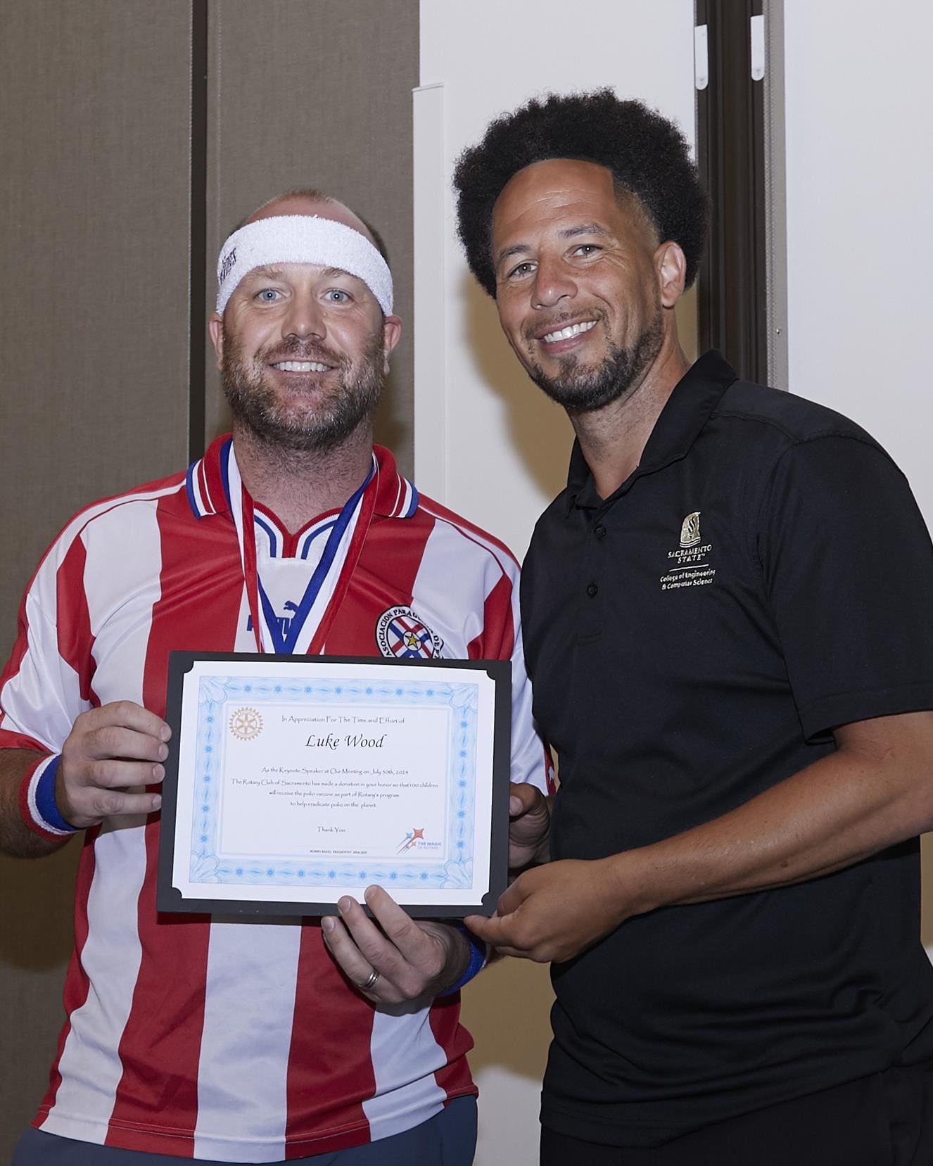 2 people smiling and holding up an appreciation paper