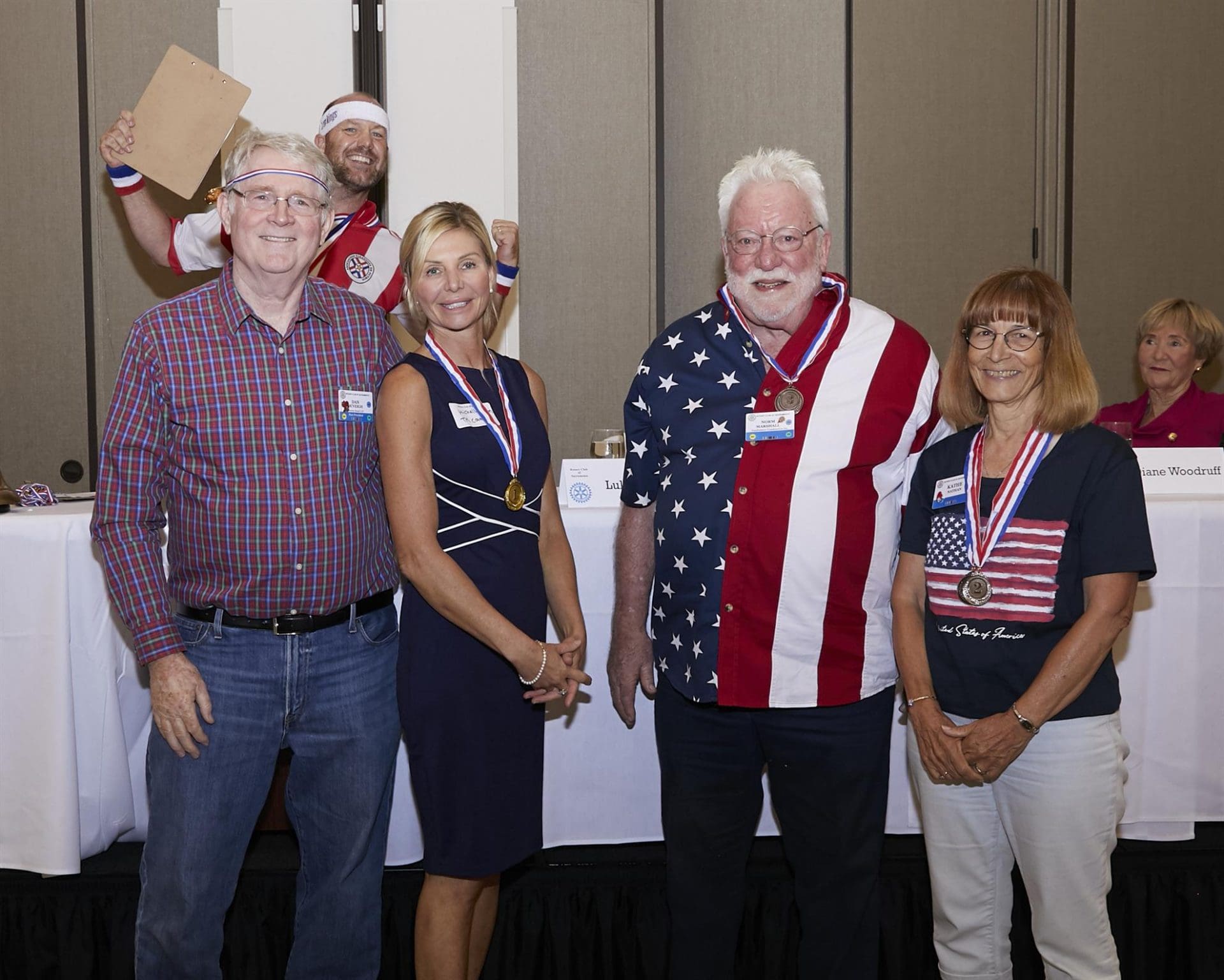 5 people smiling while 1 holds a cardboard with his hands up