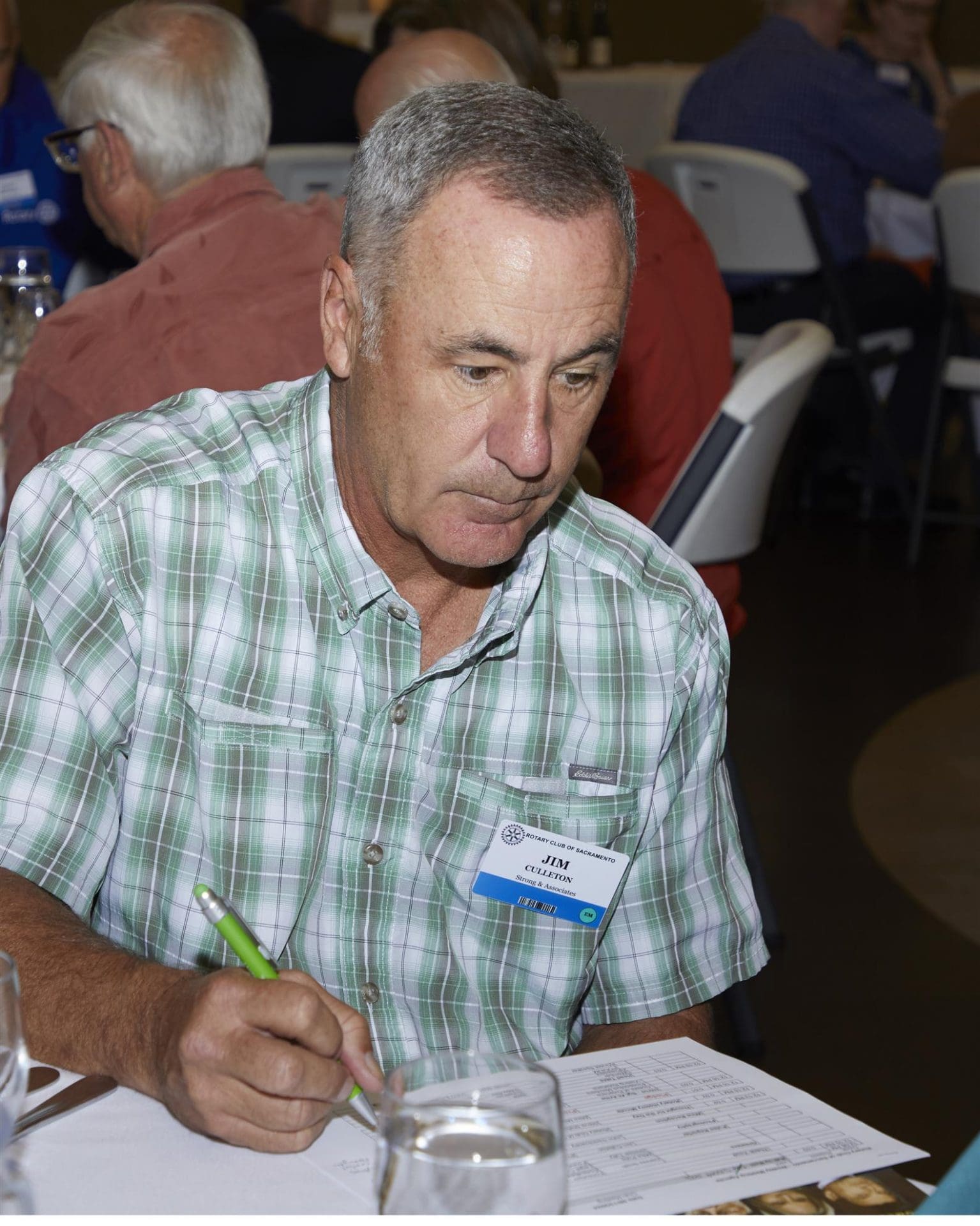 person looking down at a paper with a pencil in their hand