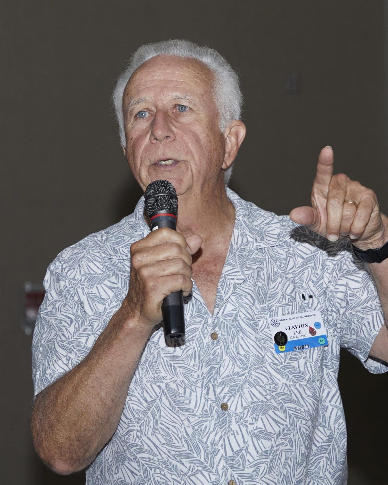 person speaking into microphone and pointing
