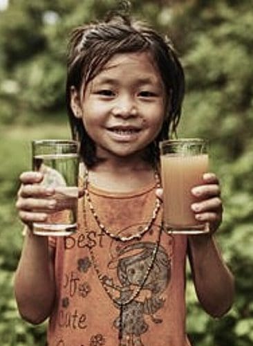 girl holding a glass of clean water and another glass of dirty water