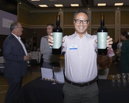 person holding wine bottles to camera