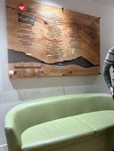 An image of a wall placard on the wall over a green couch